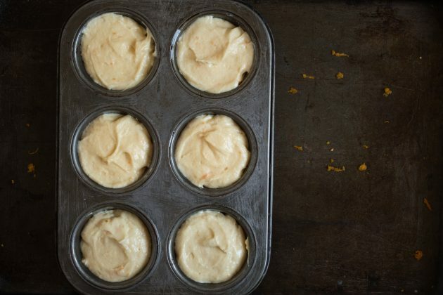 Jak připravit muffiny z mandarinky: rozdělte těsto do plechovek